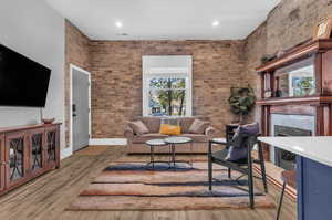 Living area featuring recessed lighting, a fireplace, wood finished floors, and a healthy amount of sunlight