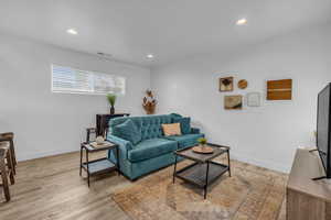 Living area featuring recessed lighting, light wood-type flooring, visible vents, and baseboards