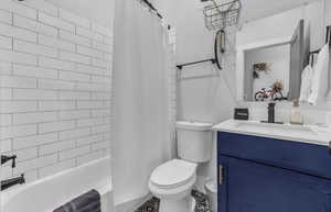 Full bathroom featuring shower / bath combo, vanity, and toilet