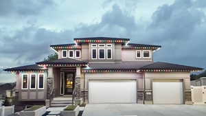 View of front of house featuring concrete driveway, an attached garage, stone siding, and stucco siding