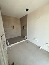Full bath with tile patterned flooring and tiled shower