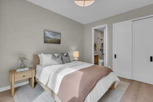 Bedroom featuring light wood-type flooring and ensuite bath