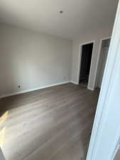 Bedroom with en suite bathroom light wood finished floors and baseboards
