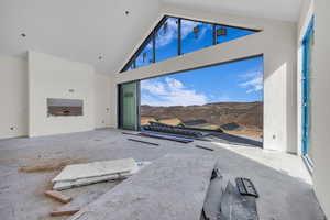 Unfurnished living room featuring a mountain view and high vaulted ceiling
