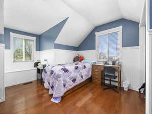 Bedroom with wainscoting, visible vents, and hardwood / wood-style floors