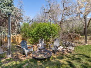 View of yard featuring an outdoor fire pit and fence