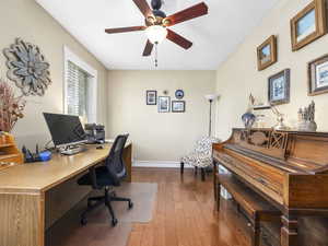 Home office featuring wood-type flooring, baseboards, and a ceiling fan