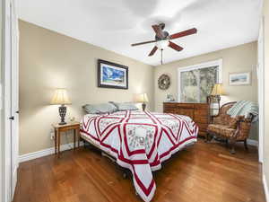 Bedroom with hardwood / wood-style flooring, baseboards, and a ceiling fan