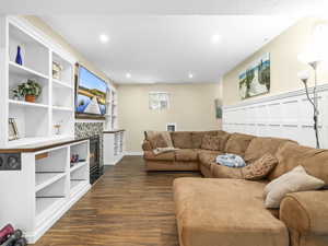 Living room with baseboards, recessed lighting, a tile fireplace, and dark wood finished floors