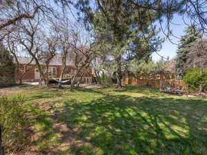 View of yard with a deck and fence