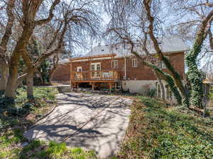 Rear view of house with a deck and brick siding