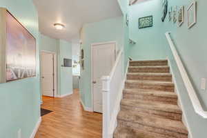 Staircase with baseboards and wood finished floors