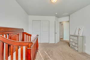 Carpeted bedroom featuring a closet and baseboards