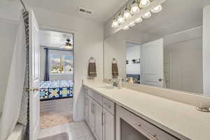 Ensuite bathroom with vanity, tile patterned floors, ensuite bath, a ceiling fan, and visible vents