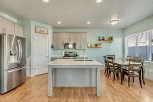 Kitchen featuring recessed lighting, light countertops, light wood-style floors, stainless steel appliances, and a sink