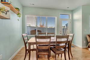 Dining room with light wood-style floors, visible vents, and baseboards