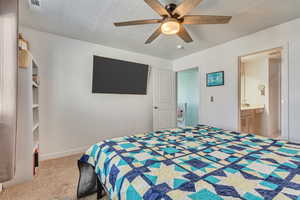 Carpeted bedroom with visible vents, baseboards, and a ceiling fan