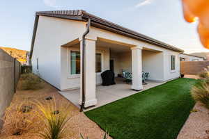 Rear view of property featuring a fenced backyard, a patio, and stucco siding