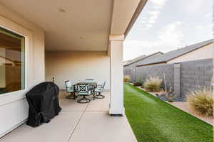 View of patio featuring outdoor dining space, a grill, and fence