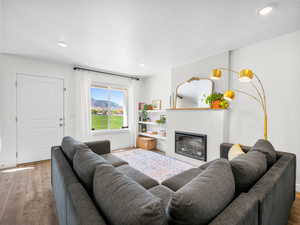 Living area with a fireplace, recessed lighting, baseboards, and wood finished floors