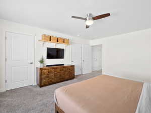 Carpeted bedroom featuring baseboards and a ceiling fan