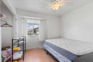 Bedroom featuring wood finished floors, ceiling fan, baseboards, and visible vents