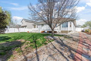 View of front of property featuring a fenced backyard, a front yard, and a deck