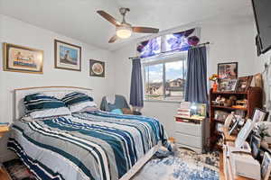 Bedroom with lofted ceiling, ceiling fan, baseboards, and wood finished floors