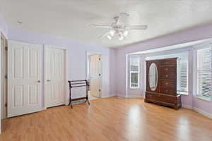 Unfurnished bedroom featuring light wood-type flooring, baseboards, and multiple windows