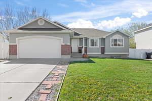 View of front of house featuring brick siding, an attached garage, fence, and stucco siding