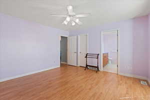 Unfurnished bedroom featuring visible vents, baseboards, ceiling fan, light wood finished floors, and connected bathroom