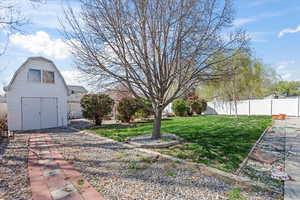 View of yard with a storage shed, an outdoor structure, and fence private yard