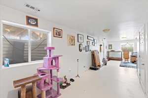 Interior space featuring finished concrete floors, visible vents, and baseboards