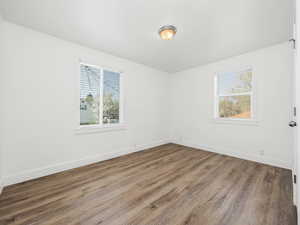 Spare room with baseboards and wood finished floors