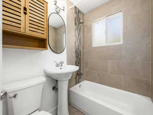Full bathroom with toilet, a sink, and shower / washtub combination