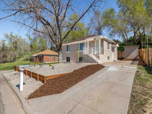 Bungalow-style house featuring concrete driveway and fence