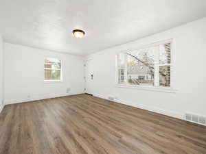 Unfurnished room with visible vents, baseboards, and wood finished floors