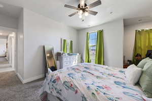 Carpeted bedroom featuring visible vents, baseboards, and a ceiling fan