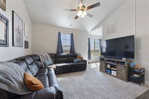 Living room featuring carpet flooring, ceiling fan, vaulted ceiling, and visible vents