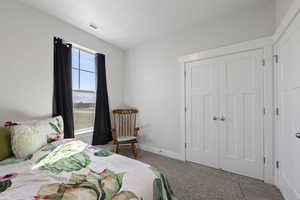 Carpeted bedroom featuring a closet and visible vents