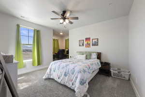 Carpeted bedroom featuring visible vents, baseboards, and ceiling fan