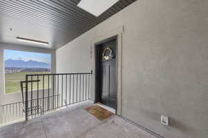 View of exterior entry featuring a balcony, stucco siding, and a mountain view