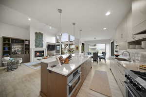 Kitchen featuring quartz countertops, a large island with prep sink, sink, and large barn style, Microwave/ convection oven and a Bluestar range