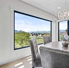 Dining space featuring wood finished floors, a mountain view, a notable chandelier, recessed lighting, and a wealth of natural light
