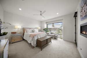 Primary Bedroom with a ceiling fan, fireplace, recessed lighting also including access to the deck