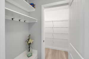 Mudroom with light wood-type flooring and baseboards