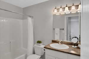 Bathroom with shower / tub combo, vanity, and toilet