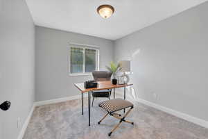Carpeted office space with baseboards