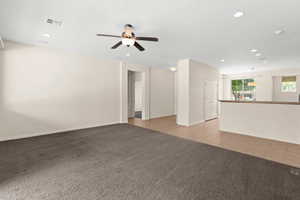 Carpeted empty room featuring visible vents, baseboards, a ceiling fan, recessed lighting, and tile patterned flooring