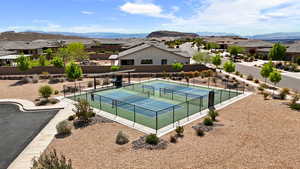 View of tennis court featuring a residential view, fence, and a mountain view